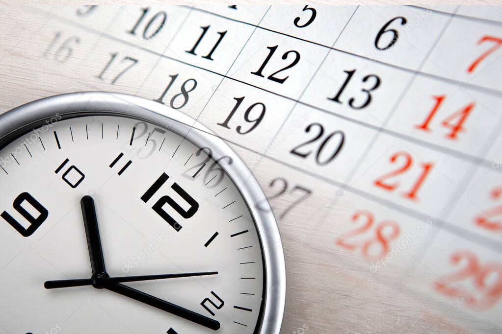 large white clock face with calendar sheets closeup