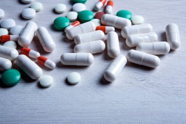 Masanın üzerine çok renkli tıbbi haplar saçılmış.