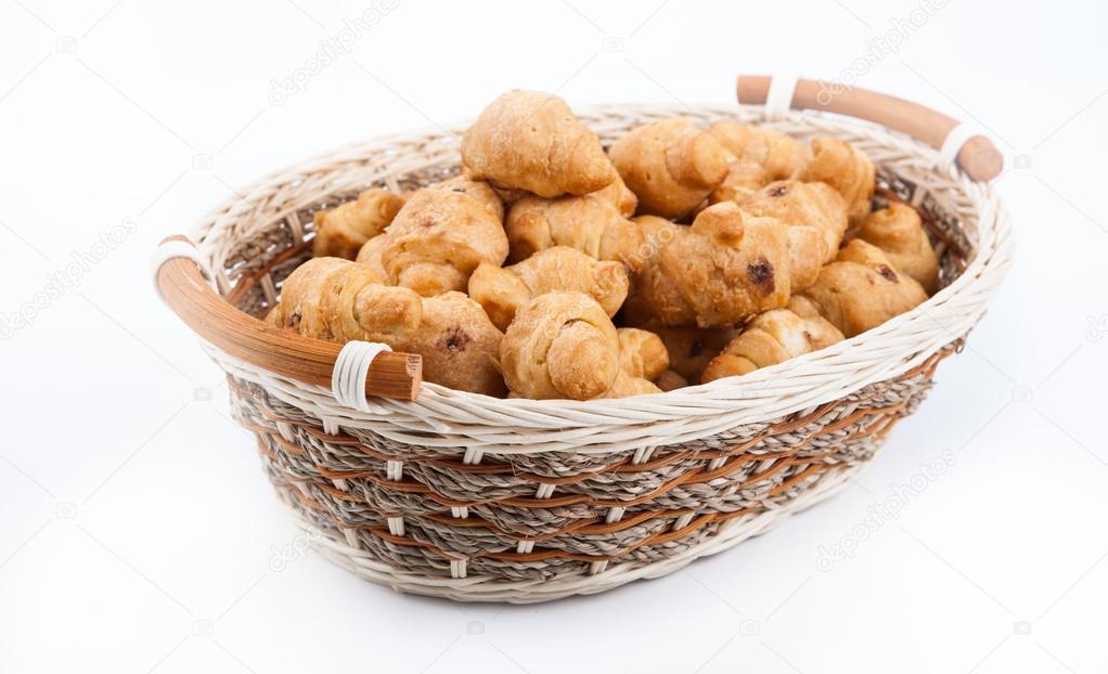 lot of sweet croissants into a bamboo bowl