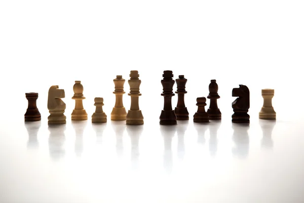 Chess pieces lined up in a row on a gray — Stock Photo, Image