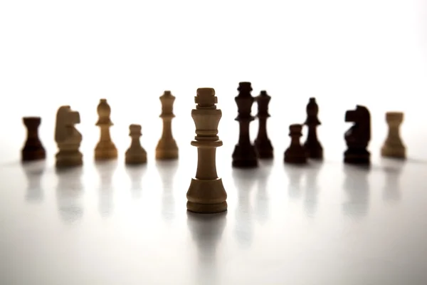 Chess pieces lined up in a row on a gray — Stock Photo, Image