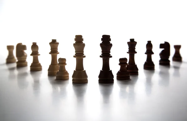 Chess pieces lined up in a row on a gray — Stock Photo, Image