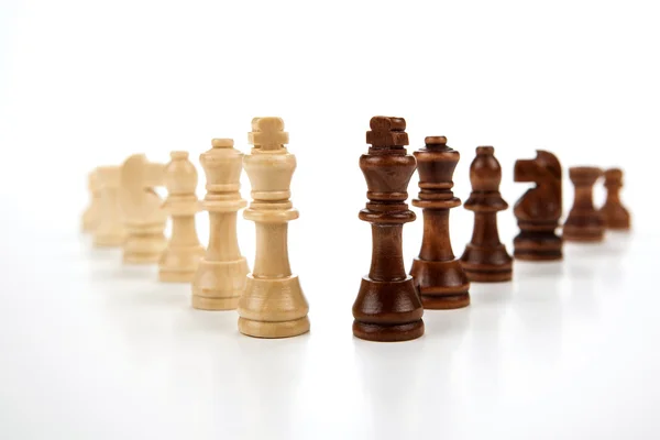 Chess pieces lined up in a row on a gray — Stock Photo, Image