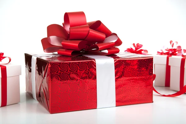 Uma caixa de presente vermelho caixas de presente branco em cinza — Fotografia de Stock