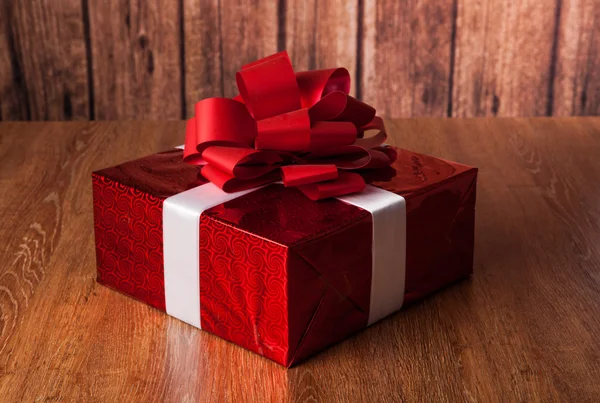 One large red gift box on a wood — Stock Photo, Image