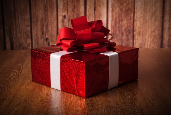 One large red gift box on a wood — Stock Photo, Image