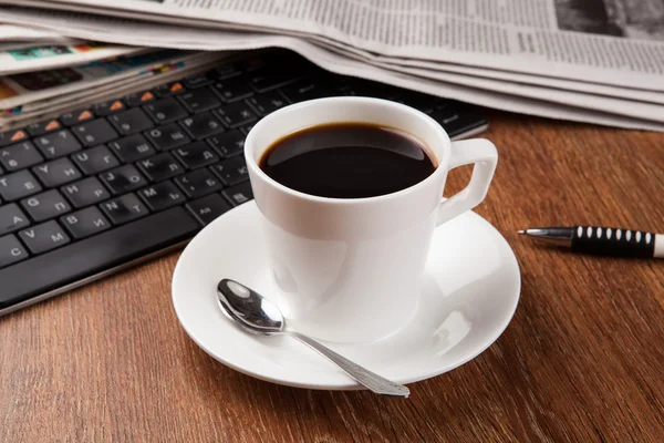 Kuppi kahvia ja sanomalehti — kuvapankkivalokuva
