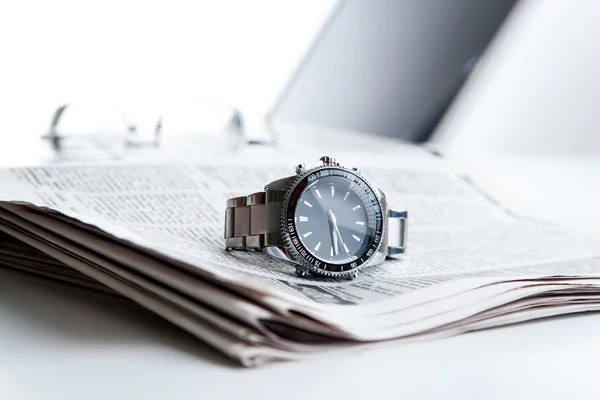 Watch businessman on newspaper — Stock Photo, Image