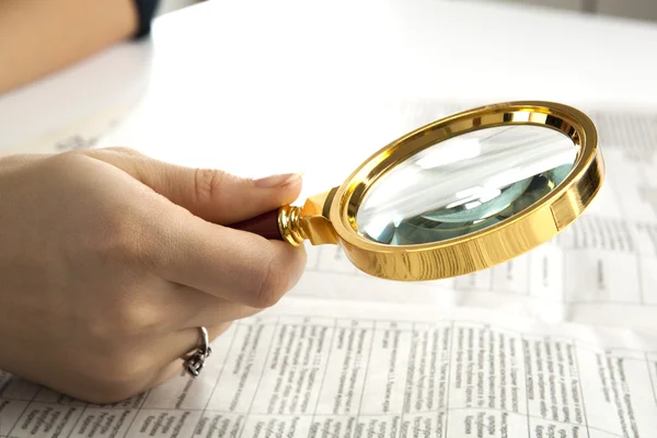 Werknemer onderzoekt een vergrootglas tekst — Stockfoto