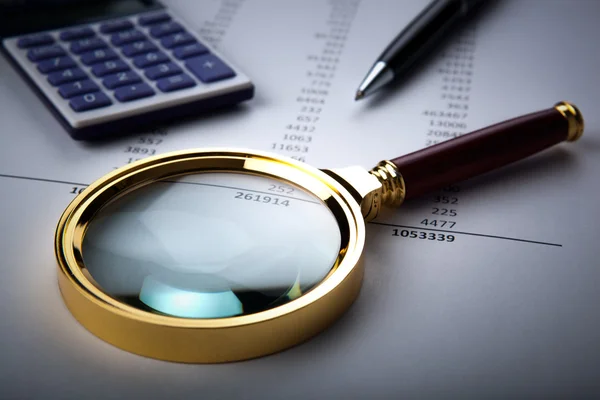 Work with a magnifying glass, a calculator — Stock Photo, Image