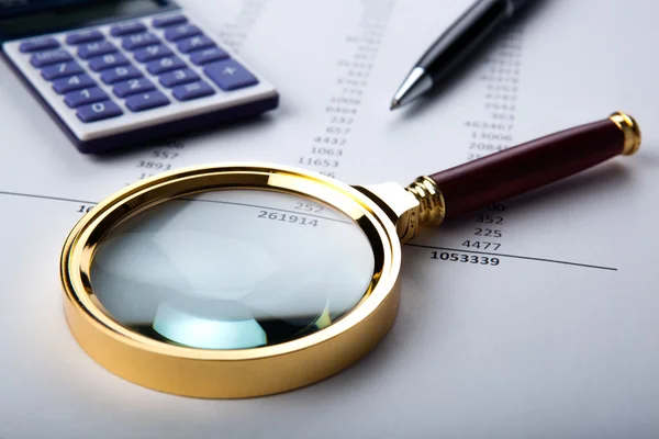 Work with a magnifying glass, a calculator — Stock Photo, Image