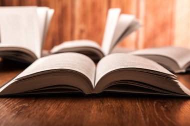 açık ahşap bir masa üzerinde büyük kitap