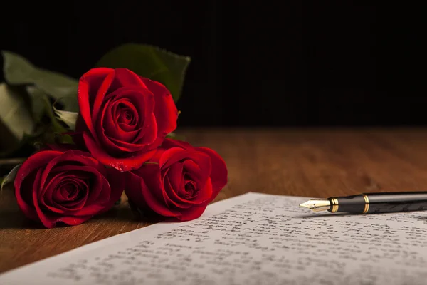 Bodegón de una pluma estilográfica, papel y flores rosas — Foto de Stock