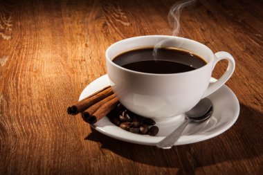 Bir fincan sade kahve ve kavrulmuş kahve çekirdekleri ile natürmort