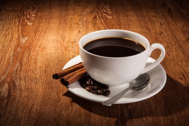 Bir fincan sade kahve ve kavrulmuş kahve çekirdekleri ile natürmort