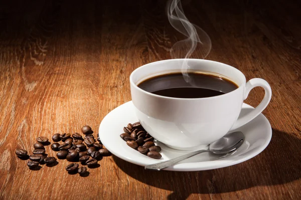 Натюрморт з чашкою чорної кави та смаженими кавовими зернами — стокове фото