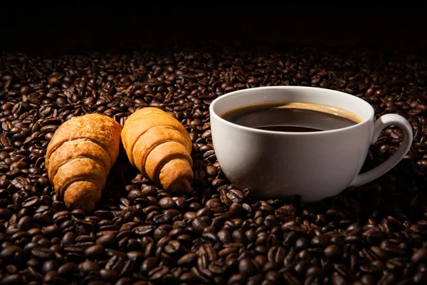 Bir fincan sade kahve ve kavrulmuş kahve çekirdekleri ile natürmort — Stok fotoğraf