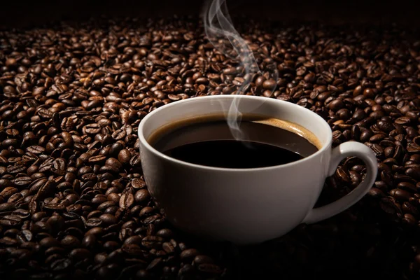 Stilleben med en kopp svart kaffe och rostade kaffebönor — Stockfoto