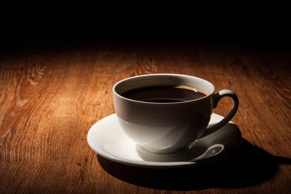 Natura morta con una tazza di caffè nero e chicchi di caffè tostati — Foto Stock