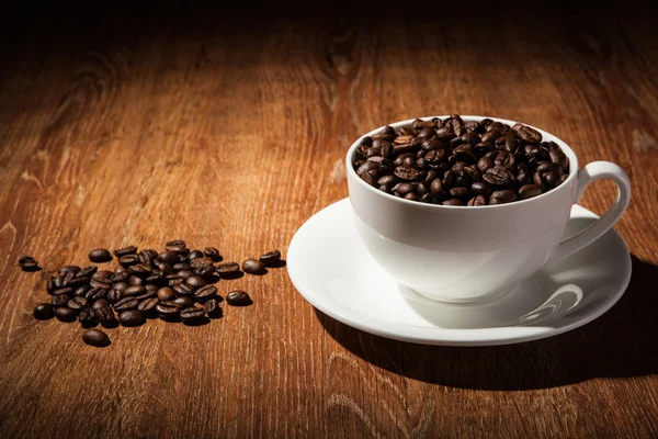 Натюрморт с чашкой кофейных зерен — стоковое фото