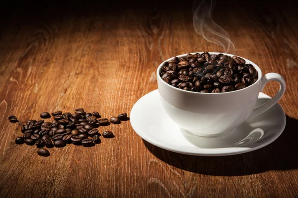Натюрморт с чашкой кофейных зерен — стоковое фото