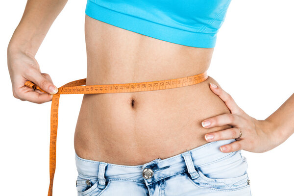 Девушка измеряет талию
