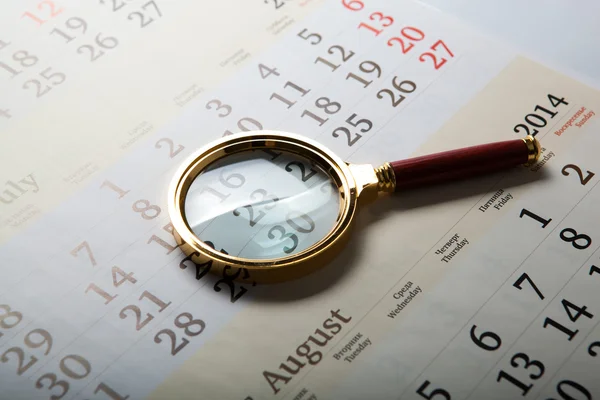 Magnifier lying on the calendar — Stock Photo, Image