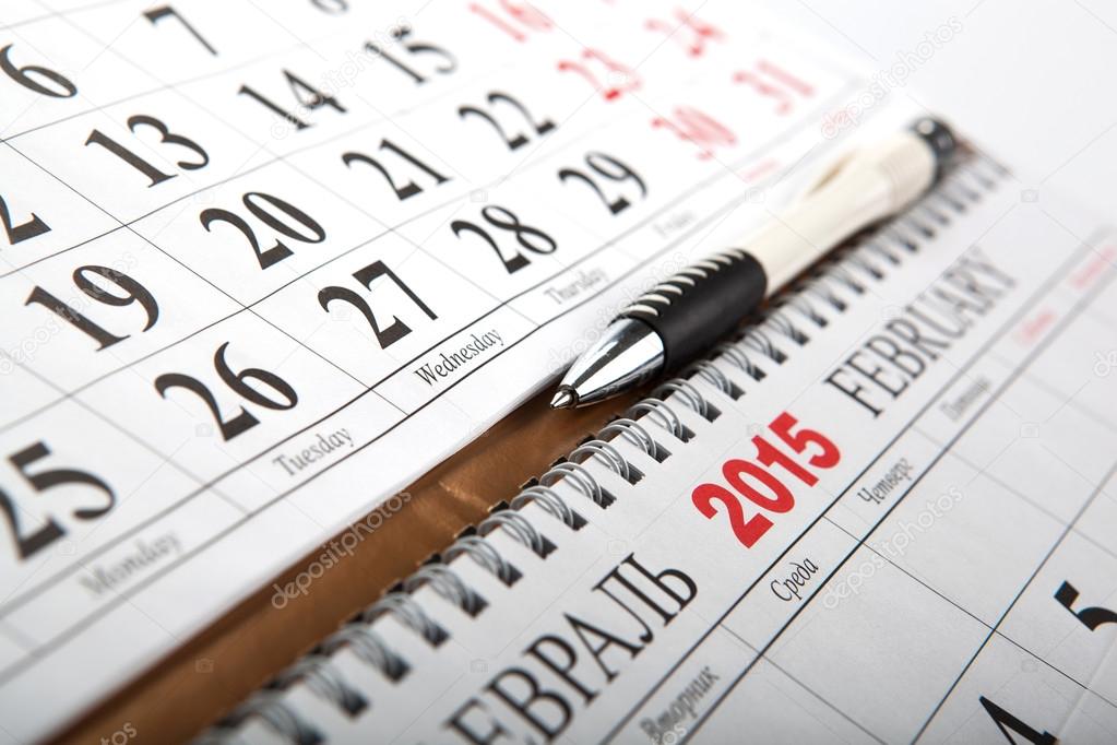 wall calendars with pen laid on the table