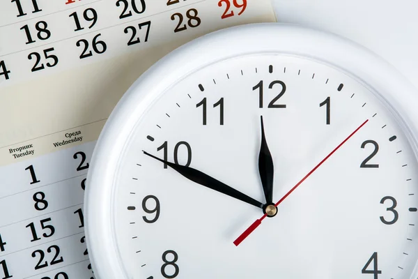 Hoja de un calendario con esfera de reloj — Foto de Stock