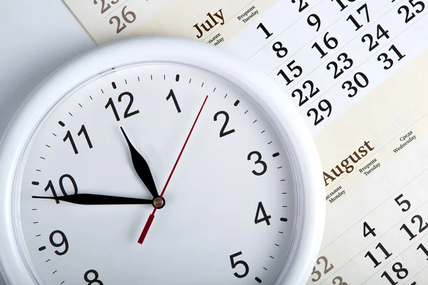 Hoja de un calendario con esfera de reloj —  Fotos de Stock