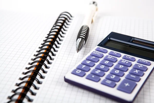 Caneta em um notebook em uma célula e calculadora — Fotografia de Stock