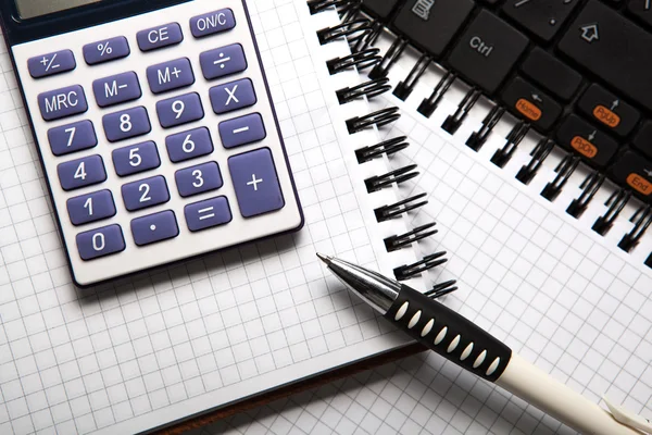 Caneta com calculadora em um notebook e teclado — Fotografia de Stock