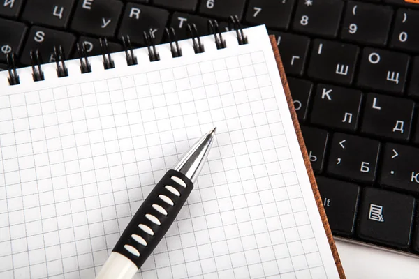 Pen on a notebook into a cell and keyboard — Stock Photo, Image