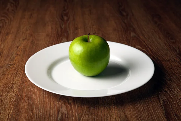 Frischer grüner Apfel auf weißem Teller — Stockfoto