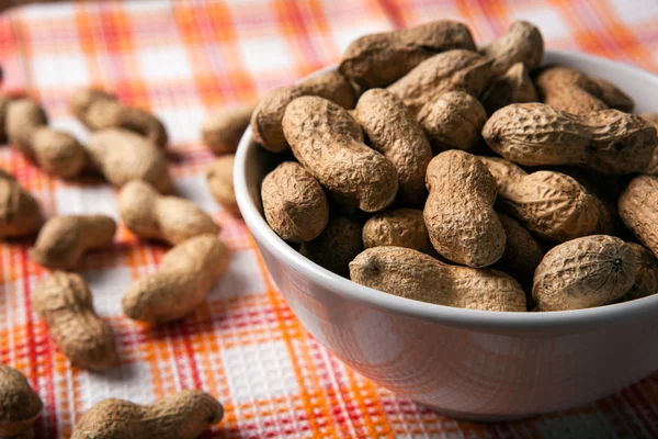 Большие зерна арахиса в скорлупе и чаше — стоковое фото