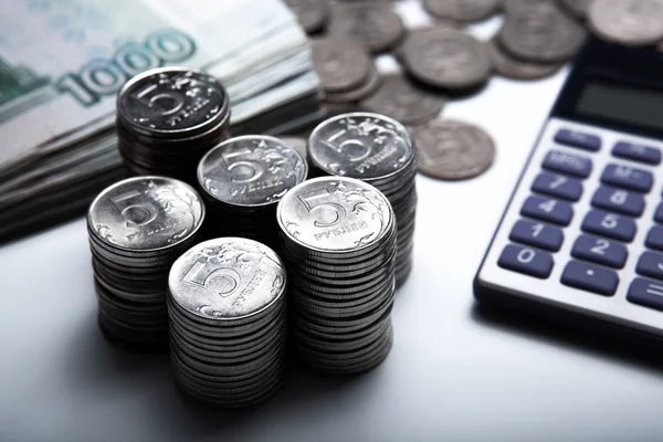 Dinero en forma de billetes y monedas con calculadora — Foto de Stock