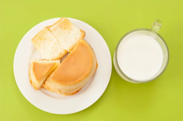 Puding torta és a tej, a zöld háttere — Stock Fotó