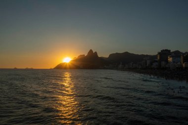 Rio de Janeiro Brezilya 'da Ipanema plajında günbatımı manzarası. Arka planda Dois Irmaos var.