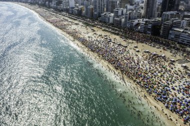 İnsansız hava aracı, Rio de Janeiro Brezilya 'daki karnaval sırasında okyanus kıyısında Ipanema sahilinde büyük bir insan kalabalığının hava görüntüsü.