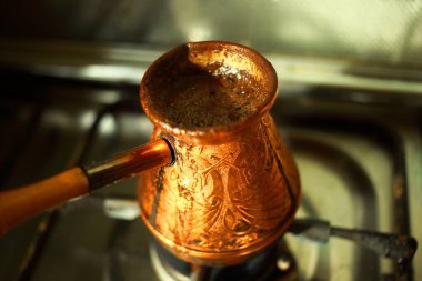 Pirinç kaplama ocağın üzerinde sıcak kahve dolu.