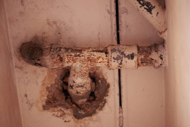 Duvardaki paslı bej borular.