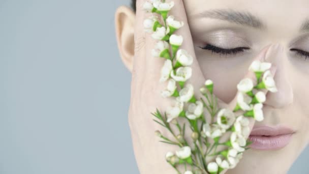 Zblízka Tvář Krásné Dívky Čistou Pletí Bílé Malé Květiny Ruce — Stock video