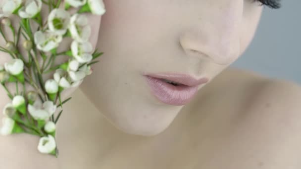 Закройте Лицо Красивой Девушки Чистой Кожей Белыми Маленькими Цветочками Руке Стоковое Видео