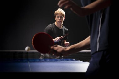 Siyah arka planda tenis oynayan genç adamın portresi