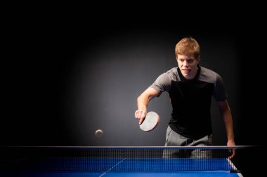 Siyah arka planda tenis oynayan genç adamın portresi