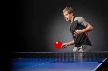 Siyah arka planda tenis oynayan genç adamın portresi