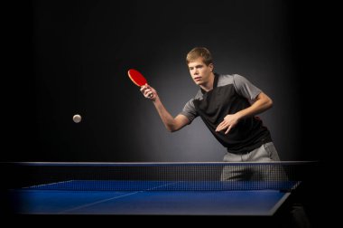 Siyah arka planda tenis oynayan genç adamın portresi