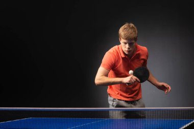 Siyah arka planda tenis oynayan genç adamın portresi