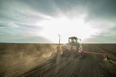 Traktör tohumu olan çiftçi - ilkbaharda tarım tarlalarına ekin ekiyor.