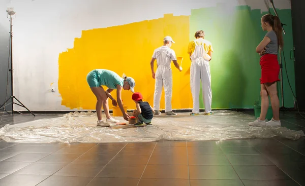 Feliz Familia Renovando Casa Dos Hombres Pintores Sobre Fondo Amarillo — Foto de Stock